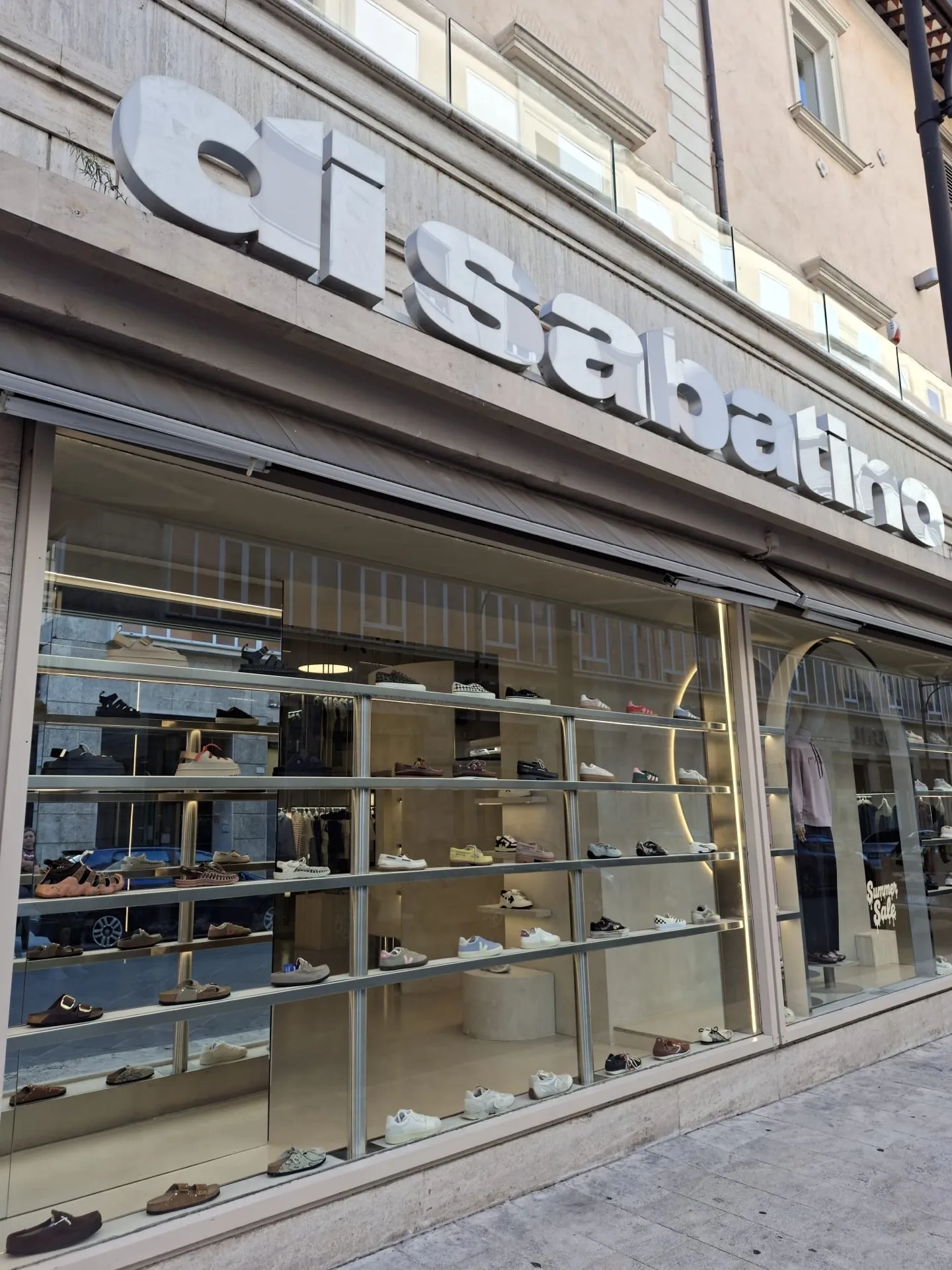 La vetrina d'ingresso con manichini e il cartello Summer Sale