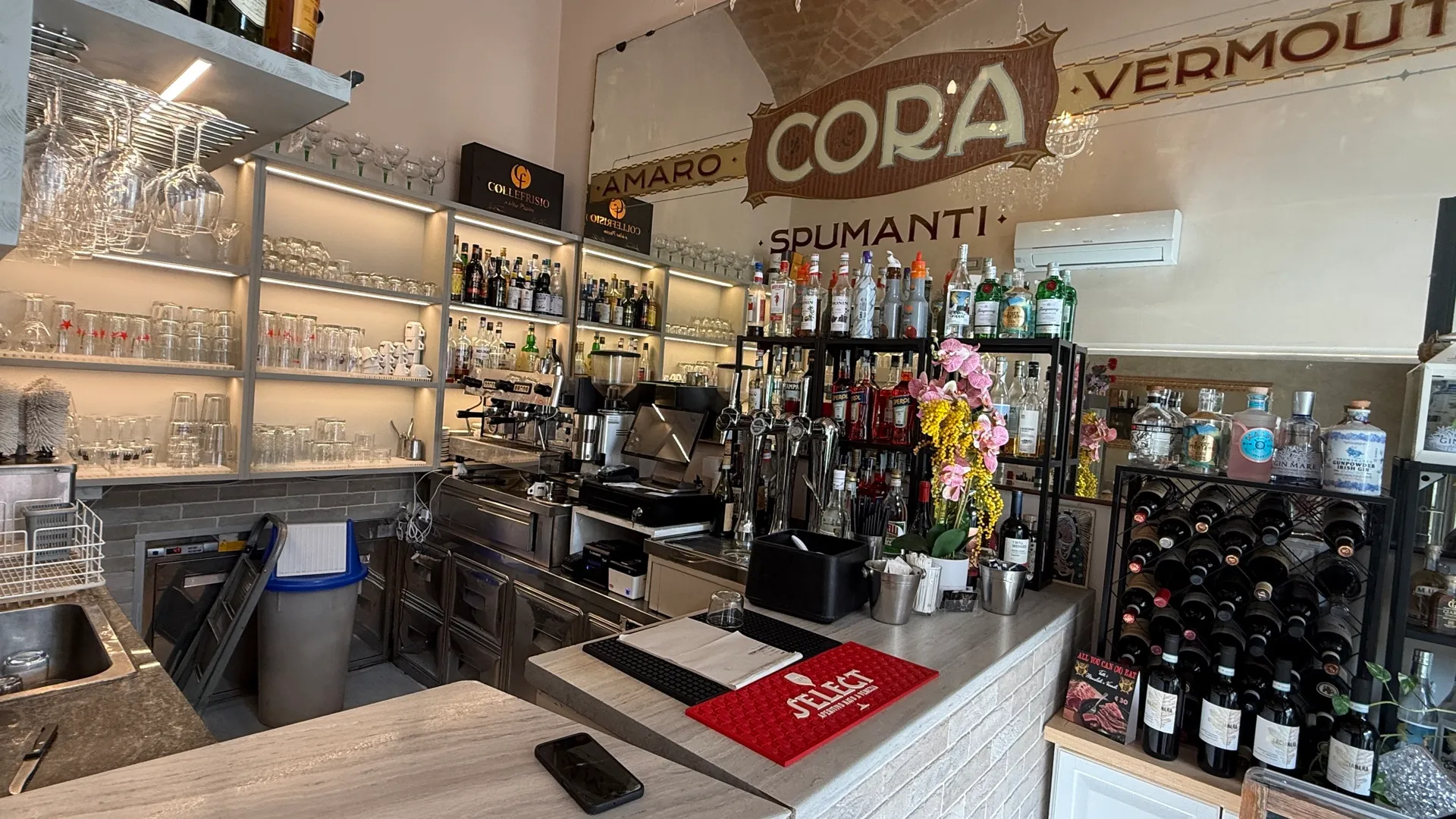 Il bancone del bar con distillati, vermouth e bicchieri