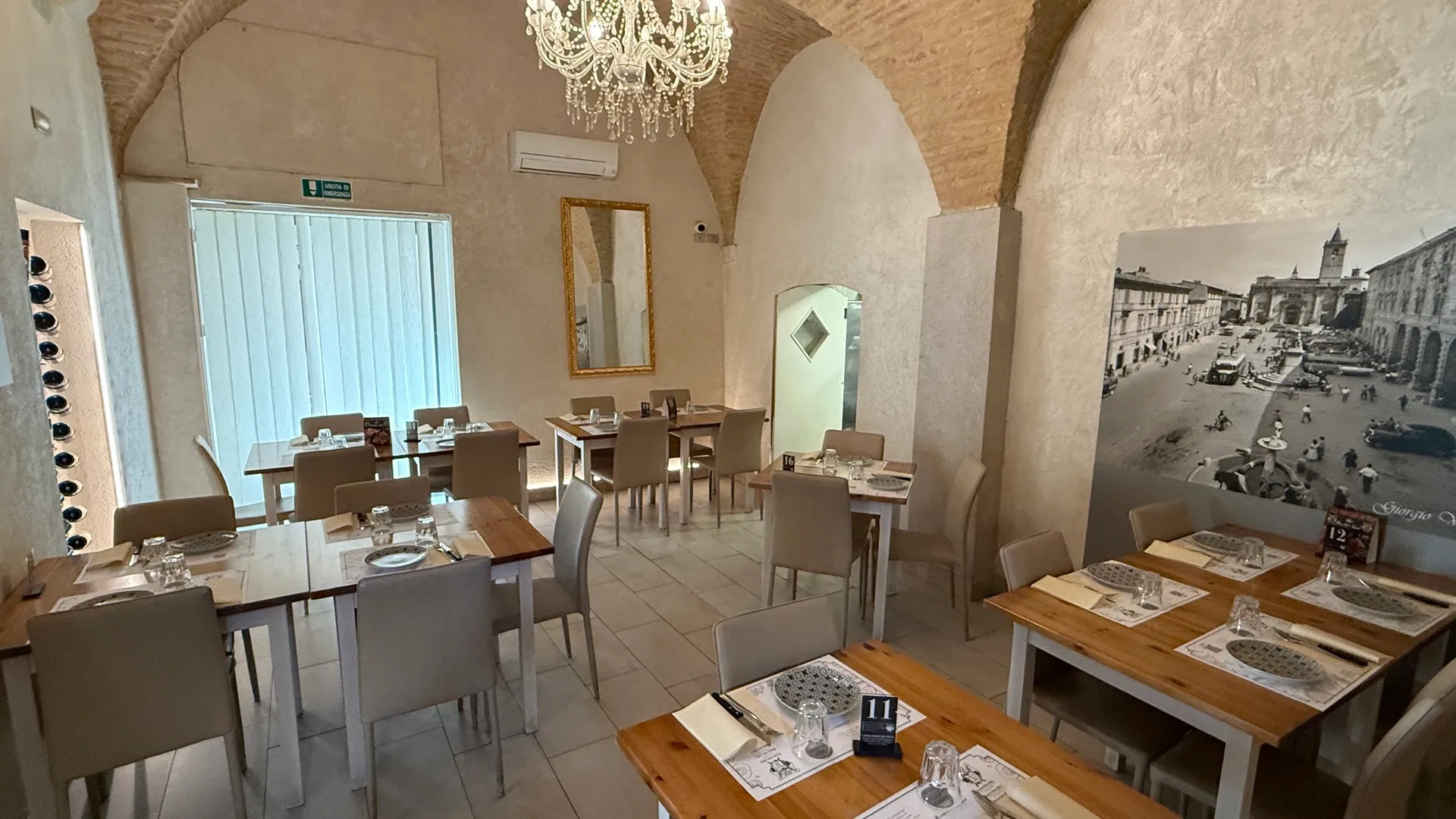 Tavoli apparecchiati nella sala principale dell'osteria