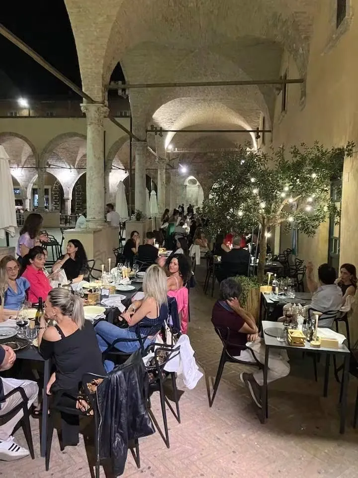 Cena estiva ai tavoli sotto le arcate del chiostro