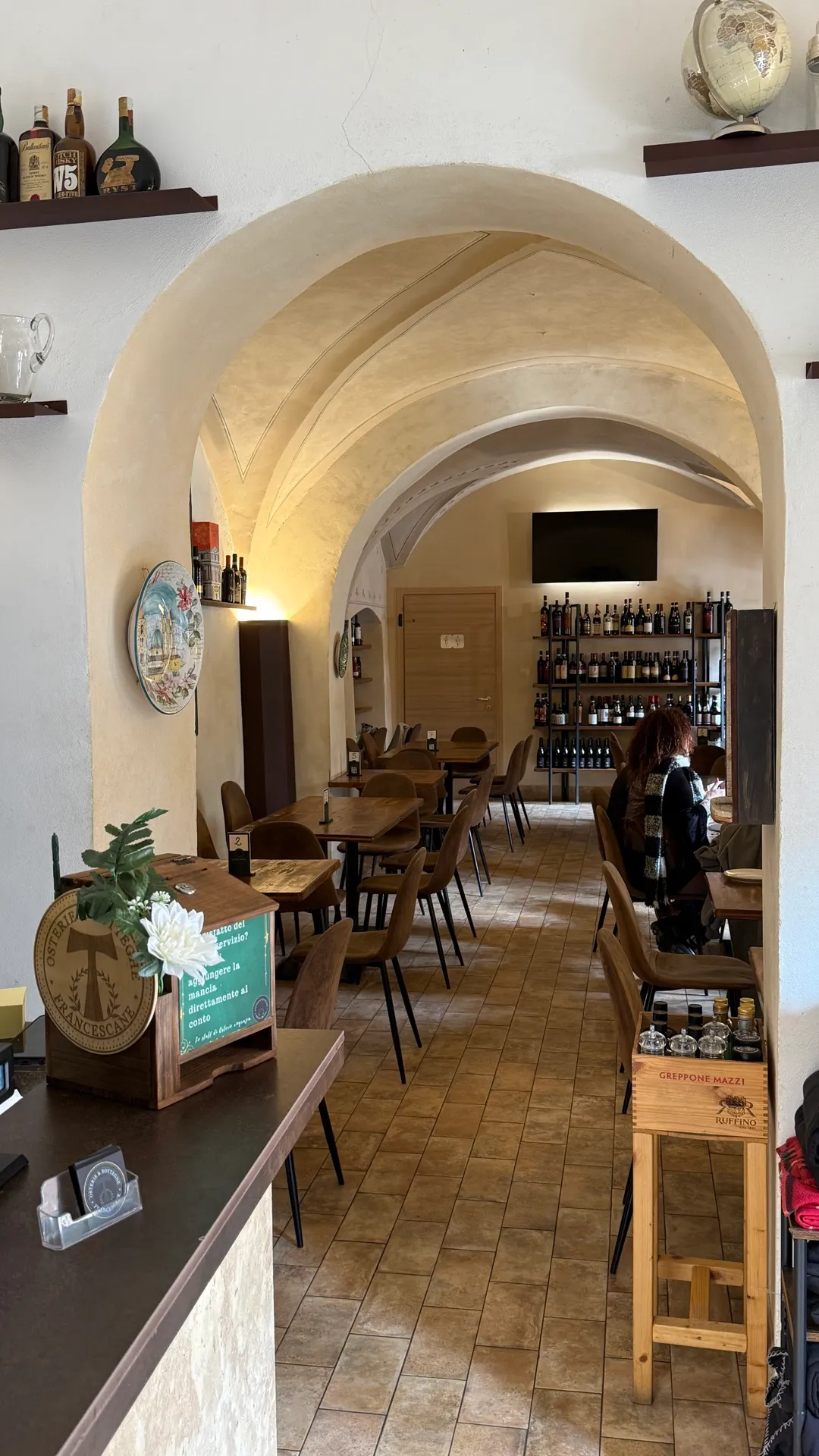 La sala interna con archi in travertino e tavoli in legno