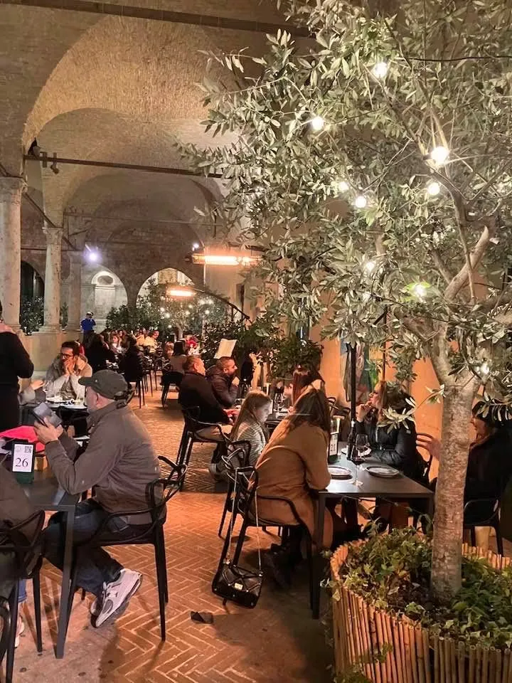 Il portico a volte illuminato la sera con i tavoli occupati