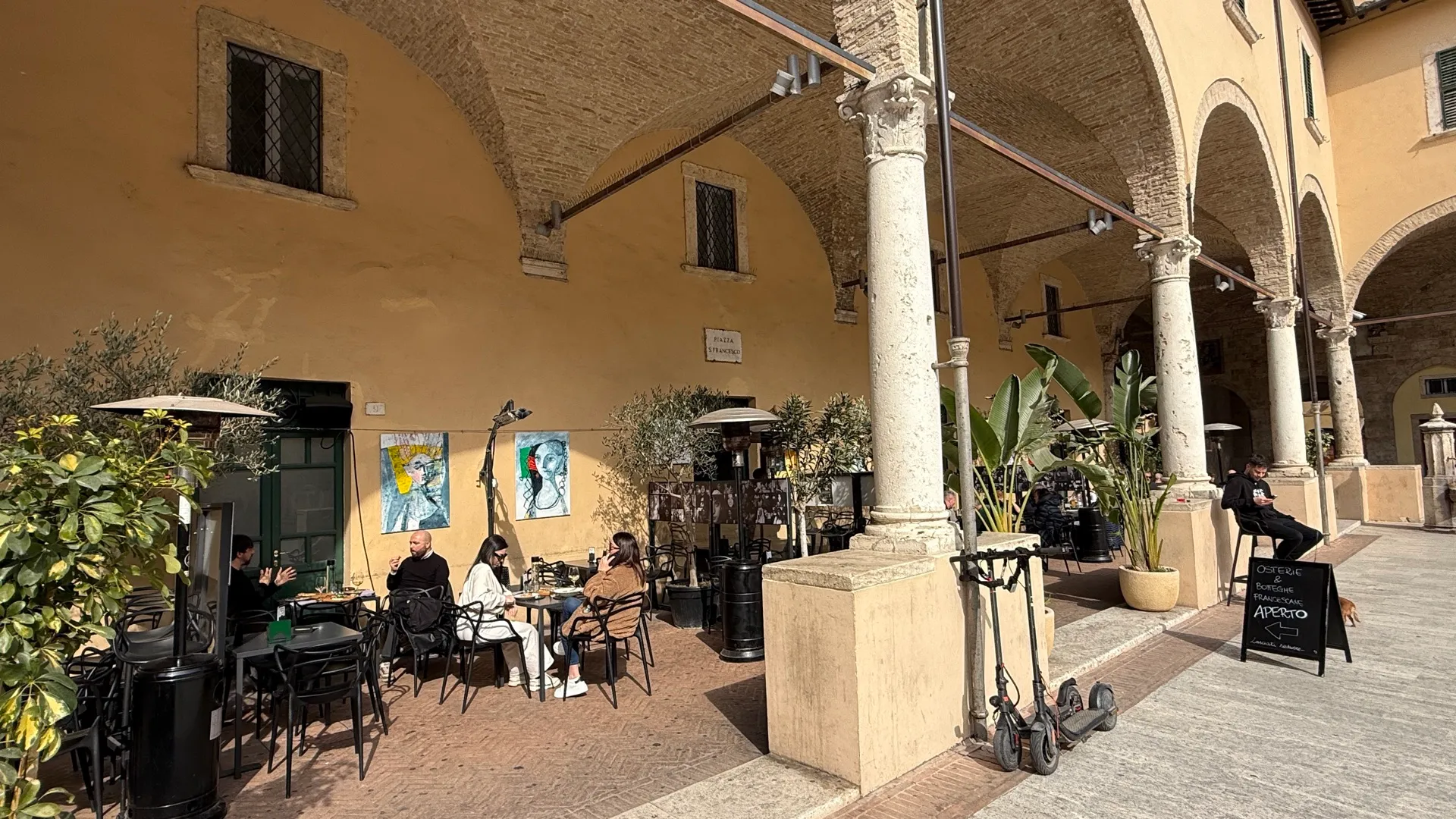 Tavoli e stufe funghi sotto le arcate del chiostro